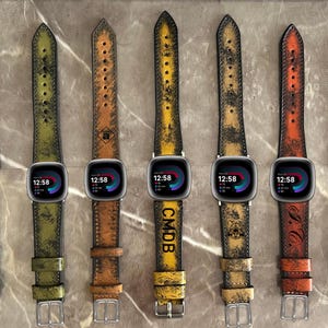 May include: Five different colored leather watch bands with distressed and worn looks. The bands are all for smartwatches and have a black watch face with a digital clock display. The bands are in the colors green, brown, yellow, brown, and orange.
