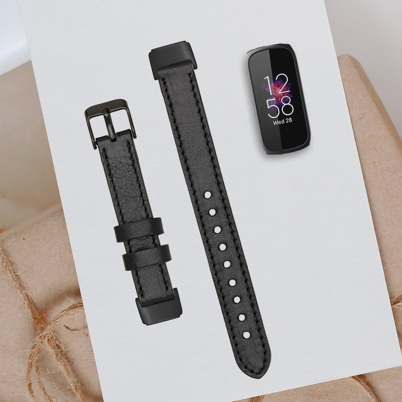 May include: Two black leather watch bands with a black metal buckle. The watch band on the left has a textured surface. The watch band on the right has a smooth surface with small holes. The watch band on the right is slightly longer than the watch band on the left.