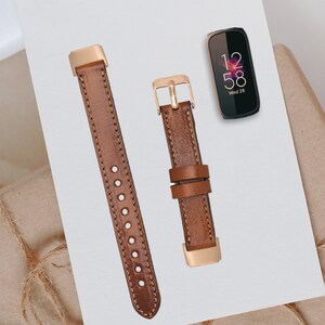 May include: Two brown leather watch bands with gold accents. The bands are shown against a white background. The band on the left has a buckle closure. The band on the right has a metal clasp.