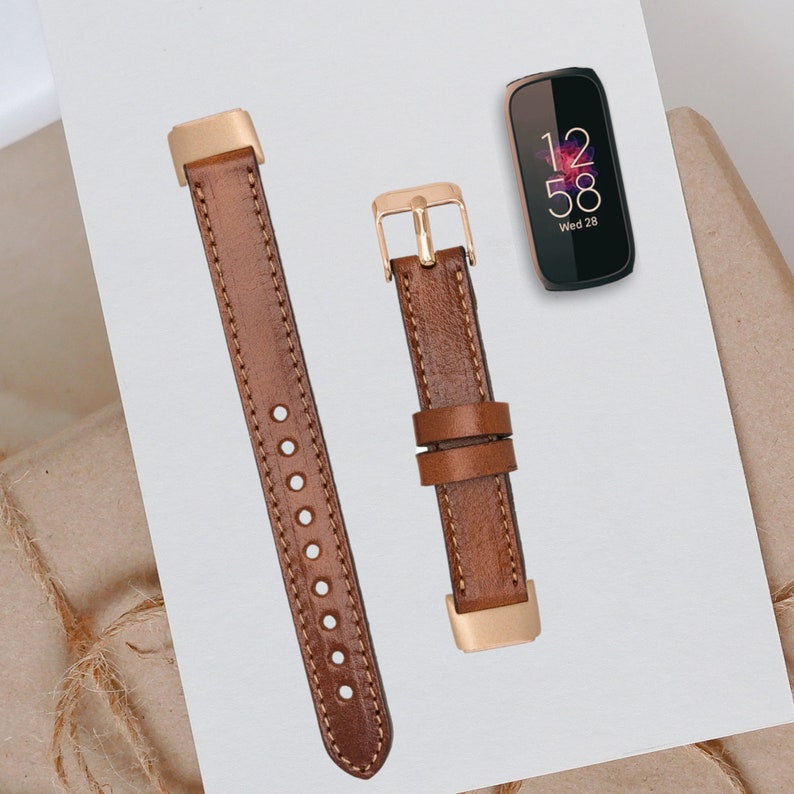 May include: Two brown leather watch bands with gold accents. The bands are shown against a white background. The band on the left has a buckle closure. The band on the right has a metal clasp.