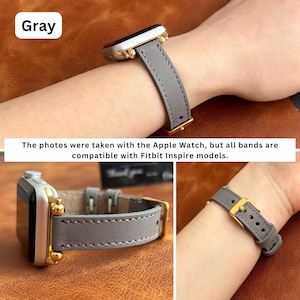May include: Gray leather watch band with gold hardware. The band is shown on a wrist and laid flat on a brown surface. "The photos were taken with the Apple Watch, but all bands are compatible with Fitbit Inspire models." is written below the image.