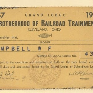May include: Vintage 1957 Brotherhood of Railroad Trainmen membership card. The tan card features the organization's name, location, and the name "CAMPBELL W F". Includes a seal and signatures. The number 438 is visible.