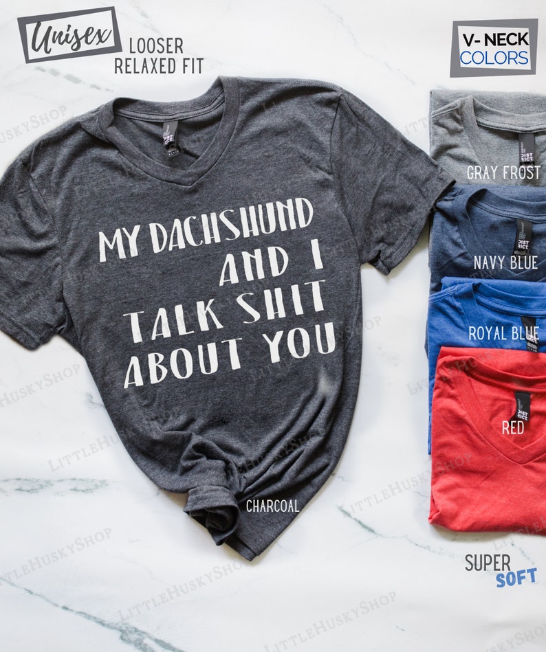Puede incluir: Una camiseta de cuello en V gris antracita con el texto "My Dachshund and I Talk Shit About You" impreso en blanco. La camiseta est&aacute; disponible en otros colores, incluyendo gris escarcha, azul marino, azul real y rojo.