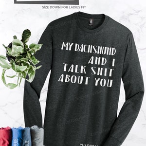 Puede incluir: Una camiseta de manga larga gris antracita con el texto "My Dachshund and I Talk Shit About You" impreso en blanco.