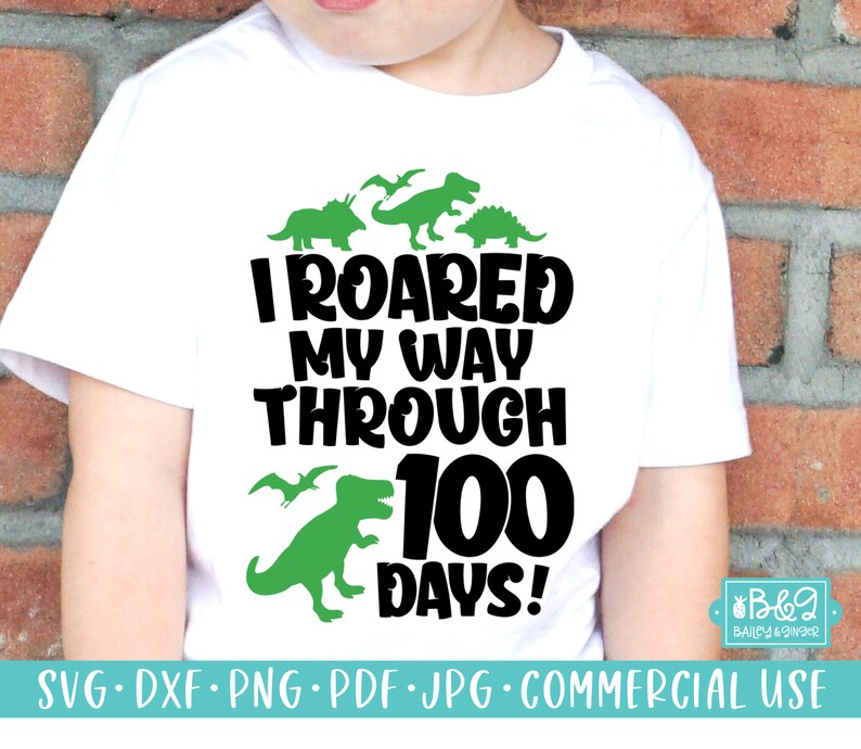 May include: A white t-shirt with a green dinosaur graphic and the text "I ROARED MY WAY THROUGH 100 DAYS!"