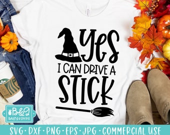 May include: A white t-shirt with a black witch hat, broom, and the text "Yes I can drive a stick".