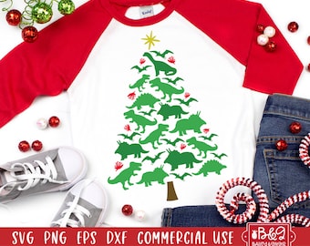 May include: A white and red baseball tee shirt with a green dinosaur Christmas tree design. The design features a star on top of the tree and a variety of dinosaurs in different poses. The text "SVG PNG EPS DXF COMMERCIAL USE" is at the bottom of the image.