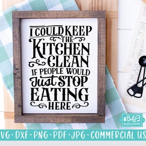 May include: A white sign with black text that reads "I could keep the kitchen clean if people would just stop eating here." The sign is framed in a dark wood frame.