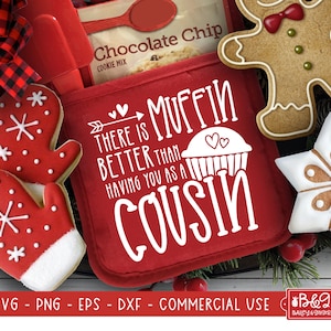 May include: Red oven mitt with white text that reads "There is muffin better than having you as a cousin". The oven mitt is surrounded by Christmas-themed decorations, including gingerbread cookies and red and white mittens.