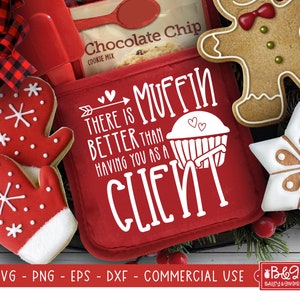 May include: Red oven mitt with white text that reads "There is muffin better than having you as a client". The text is surrounded by a heart and an arrow. The oven mitt is on a table with a gingerbread man cookie, a snowflake cookie, and a bag of chocolate chip cookie mix.