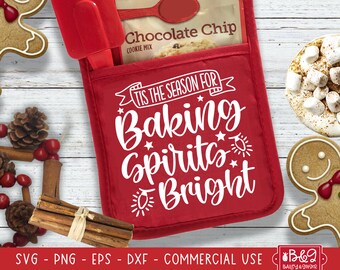 May include: Red oven mitt with the text "'Tis the season for baking spirits bright" in white. The oven mitt has a pocket on the front with a package of chocolate chip cookie mix inside.