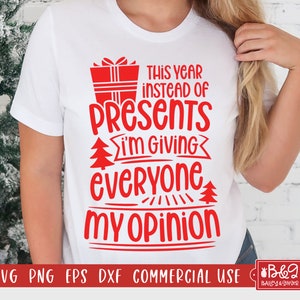 May include: White t-shirt with red text that reads "This year instead of presents I'm giving everyone my opinion". The text is surrounded by a red Christmas present box and Christmas trees.