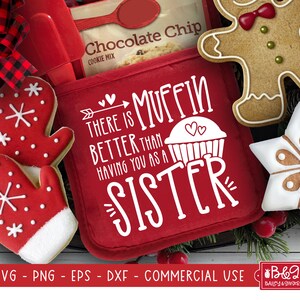 Pode incluir: Luva de forno vermelha com o texto "There is muffin better than having you as a sister" em branco. A luva de forno está cercada por biscoitos temáticos de Natal.