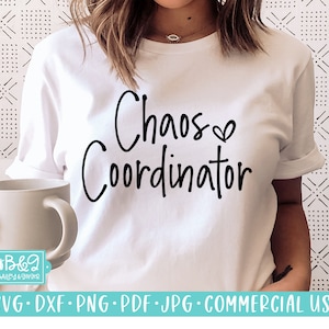 Op de afbeelding: Wit T-shirt met zwarte tekst die "Chaos Coordinator" luidt met een klein hartje na het woord "Chaos".