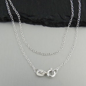 May include: A silver chain necklace with a lobster clasp closure.
