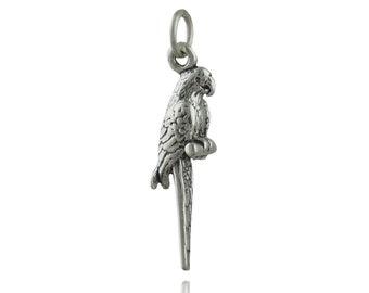May include: A silver charm in the shape of a parrot. The parrot is perched on a branch with its wings spread out.