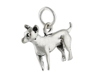 May include: A silver-colored charm in the shape of a small dog, standing with its tail up. The charm has a loop at the top for attaching to a bracelet or necklace. The dog's features are detailed, including its ears, eyes, and legs.