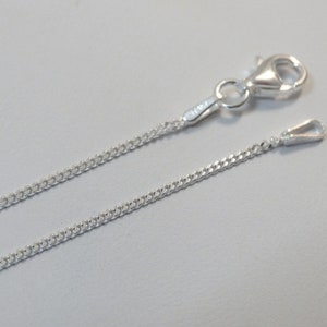 Puede incluir: Un collar de cadena de plata con cierre de mosquet&oacute;n. La cadena es de estilo curb delicado.