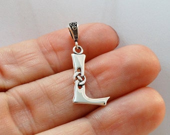 Puede incluir: Pendiente de plata con la letra L y un diseño de nudo celta. El pendiente tiene un aro para sujetarlo a una cadena.