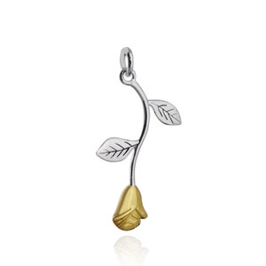 May include: A silver rose charm with a gold-toned rose bud and leaves. The charm is designed to be worn on a necklace or bracelet.