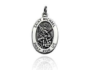 May include: Silver oval pendant with a depiction of Saint Michael the Archangel slaying a demon. The pendant reads "Saint Michael Pray For Us".