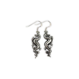 May include: A pair of silver dangle earrings featuring a detailed dragon design.