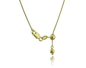May include: A gold chain necklace with a sliding clasp and a small ball at the end. The chain is thin and delicate.