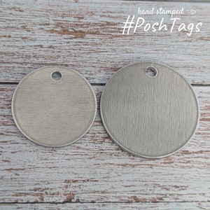 May include: Two round, silver metal tags with a hole at the top. The tags have a brushed finish and are blank.