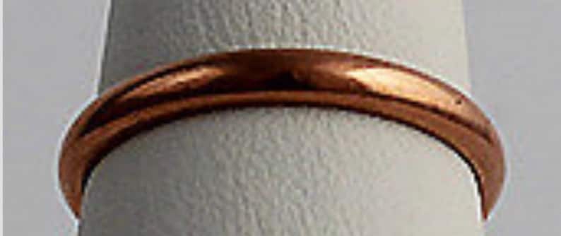 May include: A simple, plain copper band ring.
