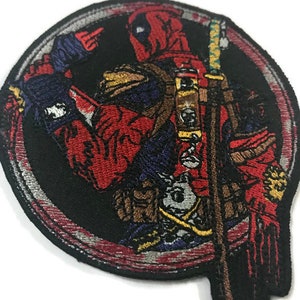 May include: Embroidered patch depicting Deadpool in a dynamic pose, set within a black circular frame. The patch showcases Deadpool's red and black costume, with a sword and intricate detailing. The design is vibrant and detailed.