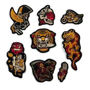 Puede incluir: Nueve parches bordados para planchar con varios diseños, incluyendo una calavera con una rosa, un tigre, un dragón, un esqueleto con una serpiente, una mujer con una rosa y una motocicleta. Los parches son todos negros con detalles dorados y rojos.