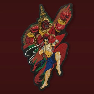 Op de afbeelding: Gestikte patch met een rode en gouden demonenfiguur met een kroon, die een vuist vasthoudt, en een man in een blauwe en witte vechtpose. De achtergrond is een rood en groen abstract ontwerp.