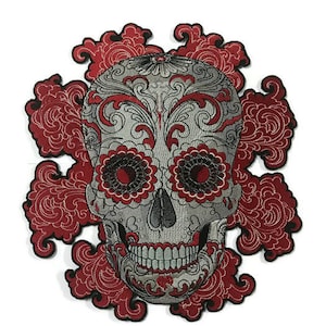 May include: Embroidered iron-on patch featuring a silver sugar skull with red floral details. The skull has intricate designs and a detailed face.