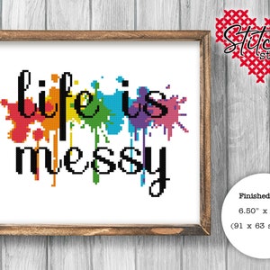 May include: Cross stitch pattern featuring the phrase "Life is messy" in black text with colorful paint splatters behind the words. The finished size is 6.50 inches by 4.50 inches, or 91 by 63 stitches.