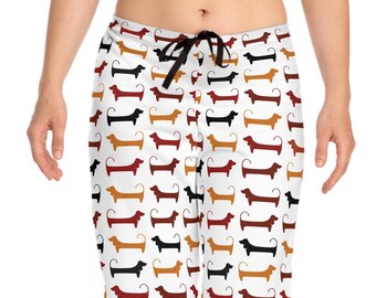 May include: White pajama pants with a repeating pattern of dachshund dogs in black, brown, orange, and red. The pants have a black drawstring at the waist. The pajama pants are made of a soft, comfortable material.