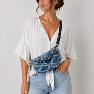 Könnte beinhalten: Eine Jeans-Bauchtasche mit Rautenmuster und einem marineblauen Riemen. Die Tasche hat einen Reißverschluss und eine kleine Quaste. Die Bauchtasche wird quer über dem Körper getragen.