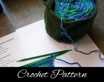 May include: A crochet pattern for a knit headband with instructions for knitting with yarn overs and knitting two stitches together. The yarn is a multi-colored blue, green, and purple yarn. The yarn is in a green crocheted basket.
