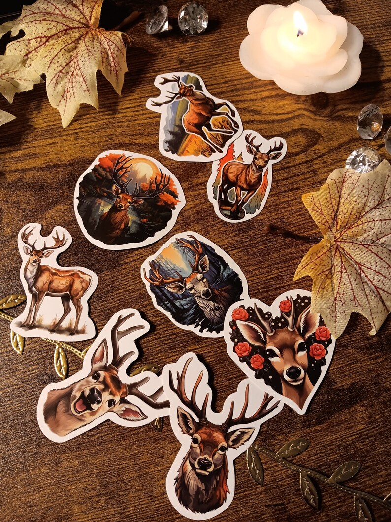 May include: Set of 7 deer stickers with various designs. The stickers feature a variety of deer in different poses, including a deer with antlers, a deer with a heart, and a deer with a flower crown. The stickers are all on a white background.