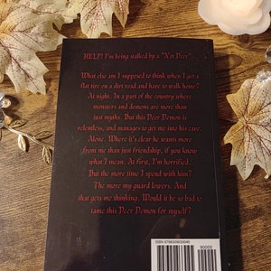 May include: A black book cover with white text that reads "HELP! I'm being stalked by a "Not Deer"."  What else am I supposed to think when I get a flat tire on a dirt road and have to walk home? At night. In a part of the country where monsters and demons are more than just myths. But this Deer Demon is relentless, and manages to get me into his cave. Alone. Where it's clear he wants more from me than just friendship, if you know what I mean. At first, I'm horrified. But the more time I spend with him? The more my guard lowers. And that gets me thinking. Would it be so bad to tame this Deer Demon for myself?"  The book cover also includes an ISBN number and barcode.