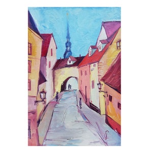 Op de afbeelding: Een schilderij van een smalle straat in een Europese stad. De straat is omzoomd met kleurrijke gebouwen, en in de verte rijst een hoge toren op. De straat is leeg, behalve voor een paar mensen die in de verte lopen.