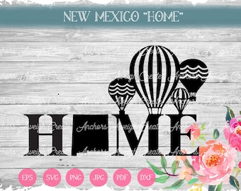 May include: Black and white silhouette of the word "HOME" with hot air balloons above the letters. The balloons have a striped pattern and are flying over a wood grain background. The word "NEW MEXICO" is written above the balloons. Pink and white watercolor flowers are in the bottom right corner of the image.