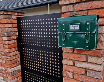 een brievenbus in de vorm van een schooltas met daarin een visitekaartje