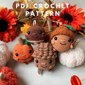 Puede incluir: Patrones de crochet para un conjunto de cinco juguetes amigurumi de temática otoñal: una calabaza, una bellota, un hongo, una piña y una calabaza blanca. Los juguetes tienen caras lindas y están hechos con hilo marrón y naranja.