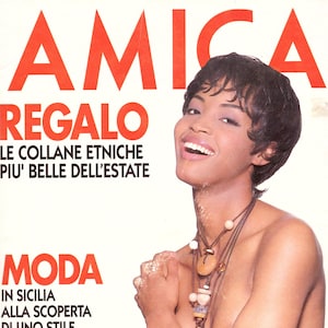 Peut inclure: Couverture de magazine avec une femme portant un collier à plusieurs rangs avec des perles en bois et en pierre. Le titre du magazine "AMICA" est en grandes lettres rouges. Le texte comprend "REGALO" et "MODA". Thème : mode et style.