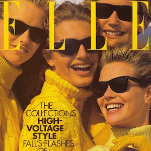 Può includere: Una copertina di rivista con tre donne che indossano maglioni gialli e occhiali da sole. La rivista si chiama "ELLE" e il titolo principale è "The Collections High-Voltage Style Fall's Flashes of Brilliance".