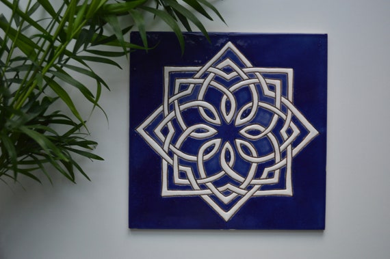 Azulejo de cerámica artesanal con diseño geométrico mediterráneo y en azul cobalto, pintado a mano con la tradicional técnica de cuerda seca