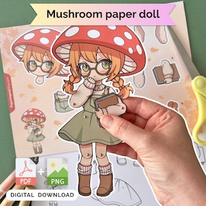 以下が含まれることがあります： キノコの帽子、メガネ、グリーンドレスを着て本を持っている紙人形。人形はデジタルダウンロードの一部で、上部に「Mushroom paper doll」というテキストがあります。画像にはPDFとPNGのアイコンが含まれています。