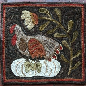Peut inclure: Un tapis de dinde brun, blanc et orange avec une citrouille blanche et une branche verte feuillue en arrière-plan. Le tapis est en laine et a un style rustique et d'art populaire.