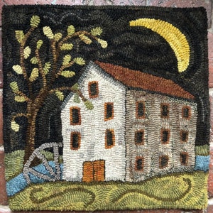 May include: Hand-hooked textile art depicting a nighttime rural scene. A white building with a brown roof and dark windows is centered, with a tree on the left and a yellow crescent moon in the dark sky. A water wheel and stream are visible.
