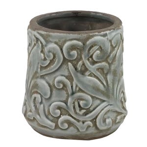 May include: A small, cylindrical ceramic planter with a light blue-green glaze. The exterior features a raised, ornate floral and scrollwork design. The rim and base have a darker, weathered appearance, adding a rustic touch. The interior is a dark gray color.